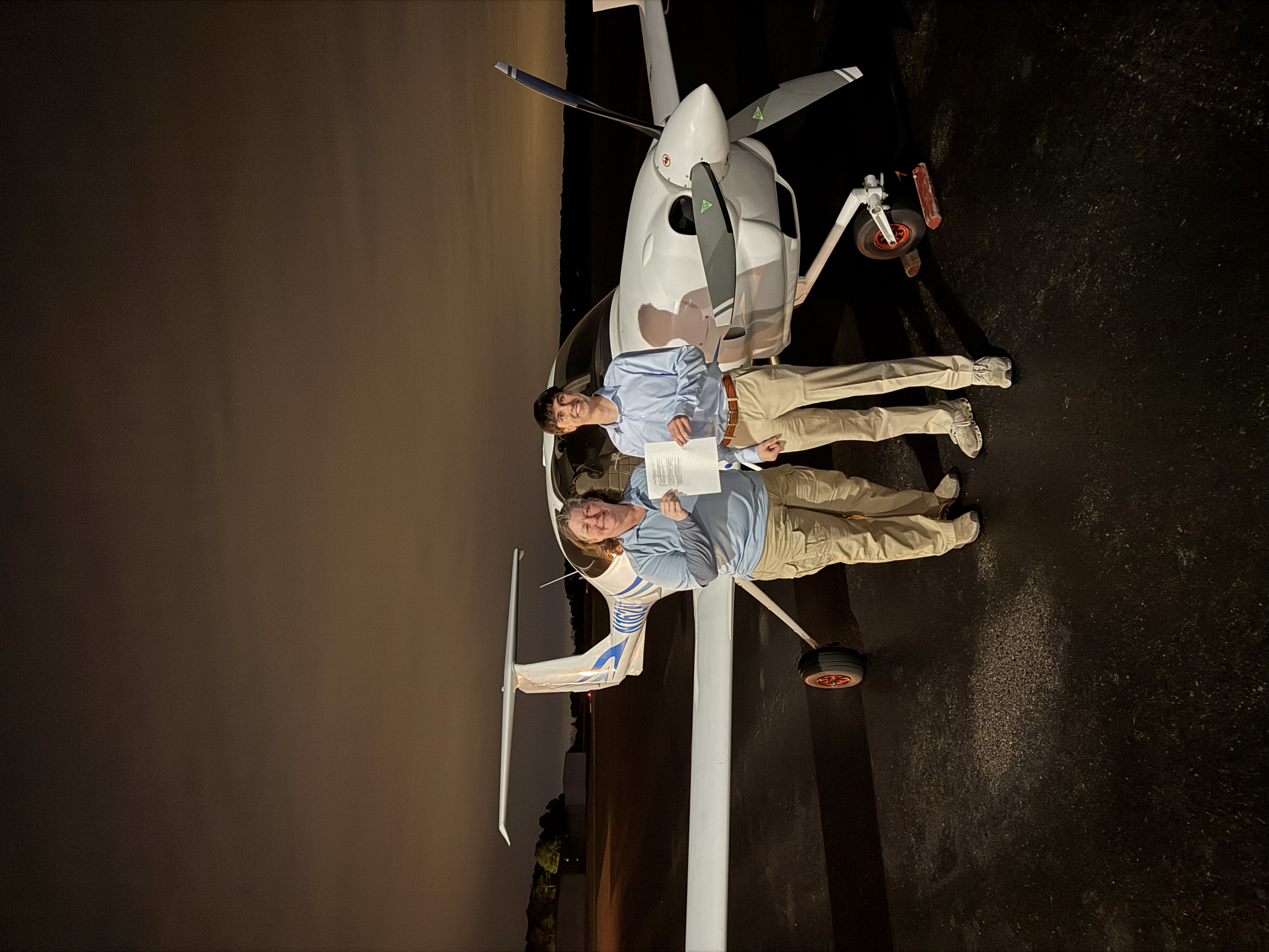 Parker Hughes celebrating after a checkride in front of a Diamond DA40